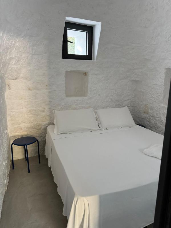 Trulli au milieu d'un champ d'oliviers avec piscine